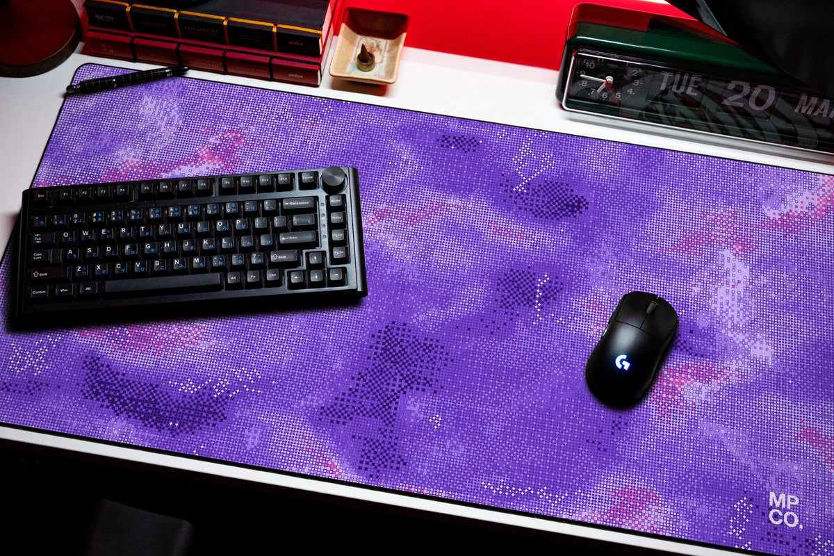 Stitch Grid desk mat in Violet, shown on a styled desk setup