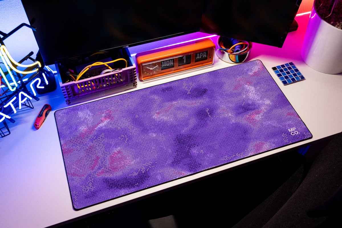 Stitch Grid desk mat in Violet, shown on a styled desk setup