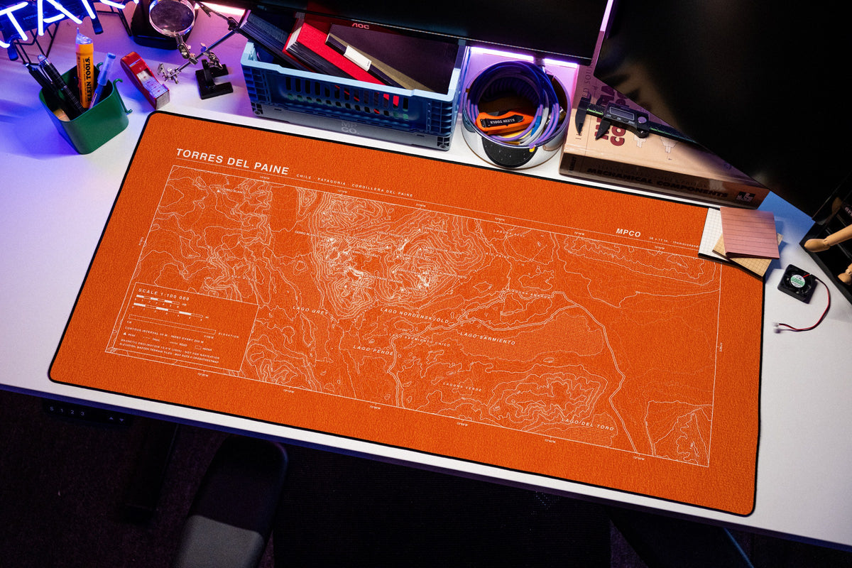 Torres del Paine Topo Pad desk mat in Orange / White, shown on a styled desk setup