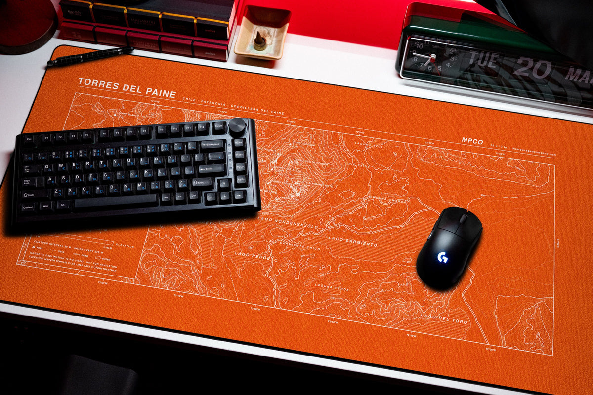 Torres del Paine Topo Pad desk mat in Orange / White, shown on a styled desk setup