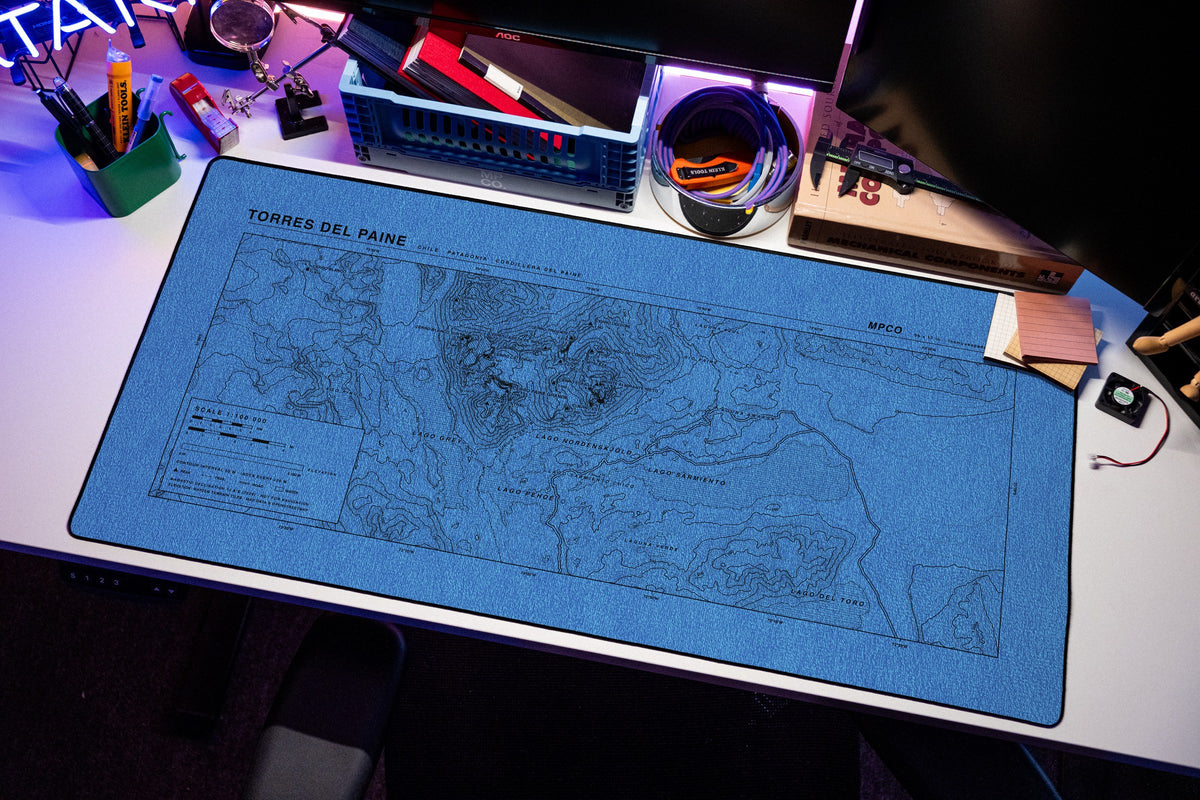 Torres del Paine Topo Pad desk mat in Swiss Blue, shown on a styled desk setup