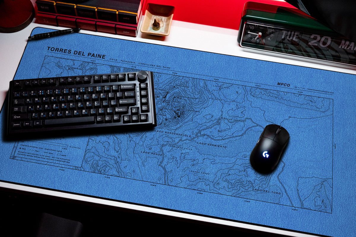Torres del Paine Topo Pad desk mat in Swiss Blue, shown on a styled desk setup