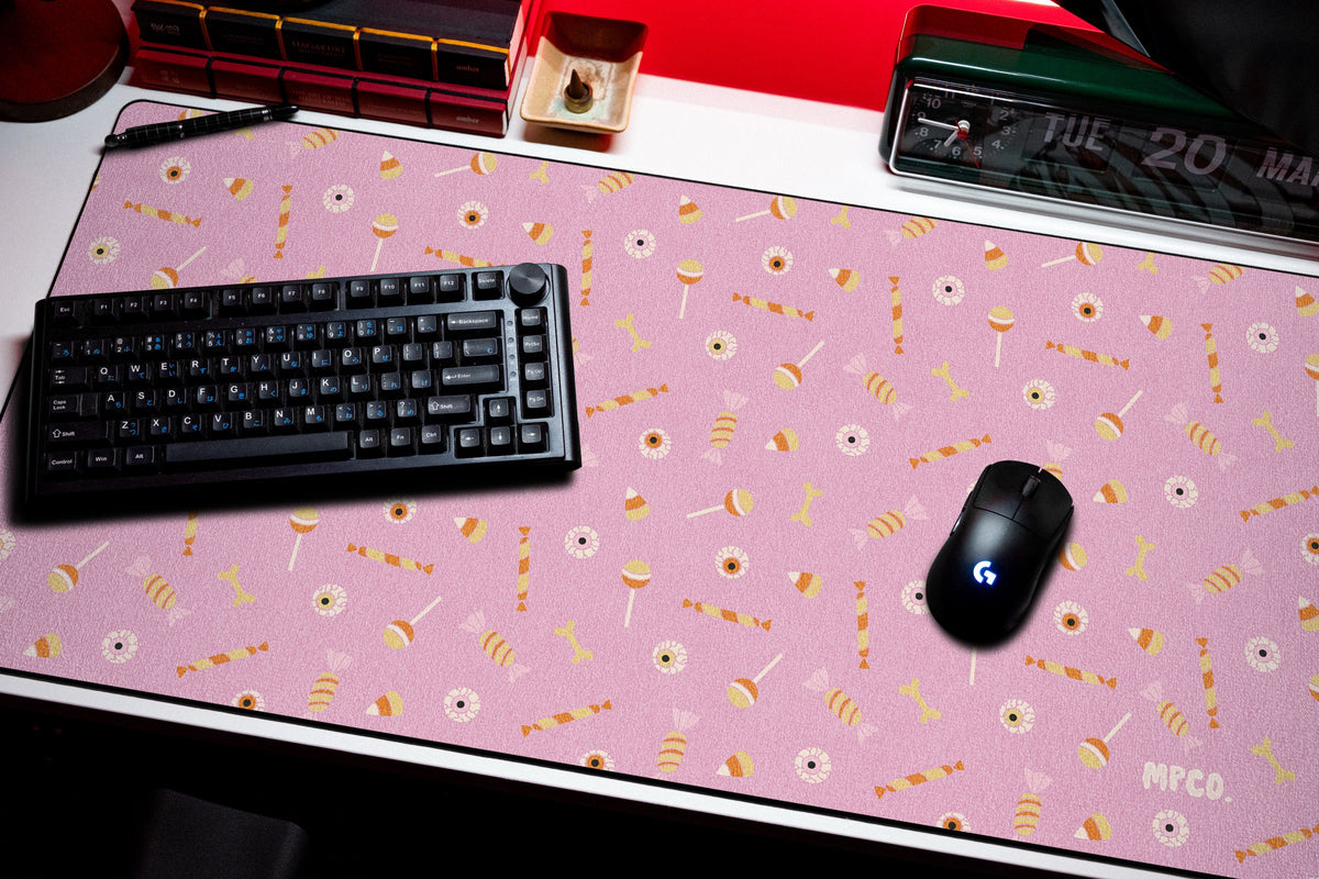 Trick or Treat desk mat in Pink, shown on a styled desk setup