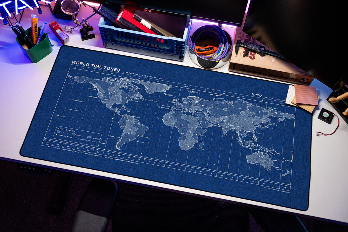 World Time Zones Map Pad desk mat in Blue / White, shown on a styled desk setup