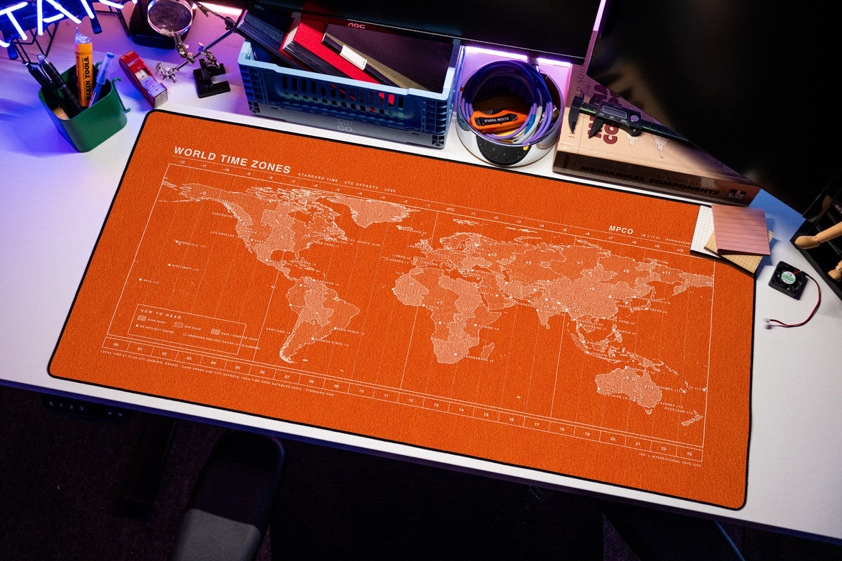 World Time Zones Map Pad desk mat in Orange / White, shown on a styled desk setup