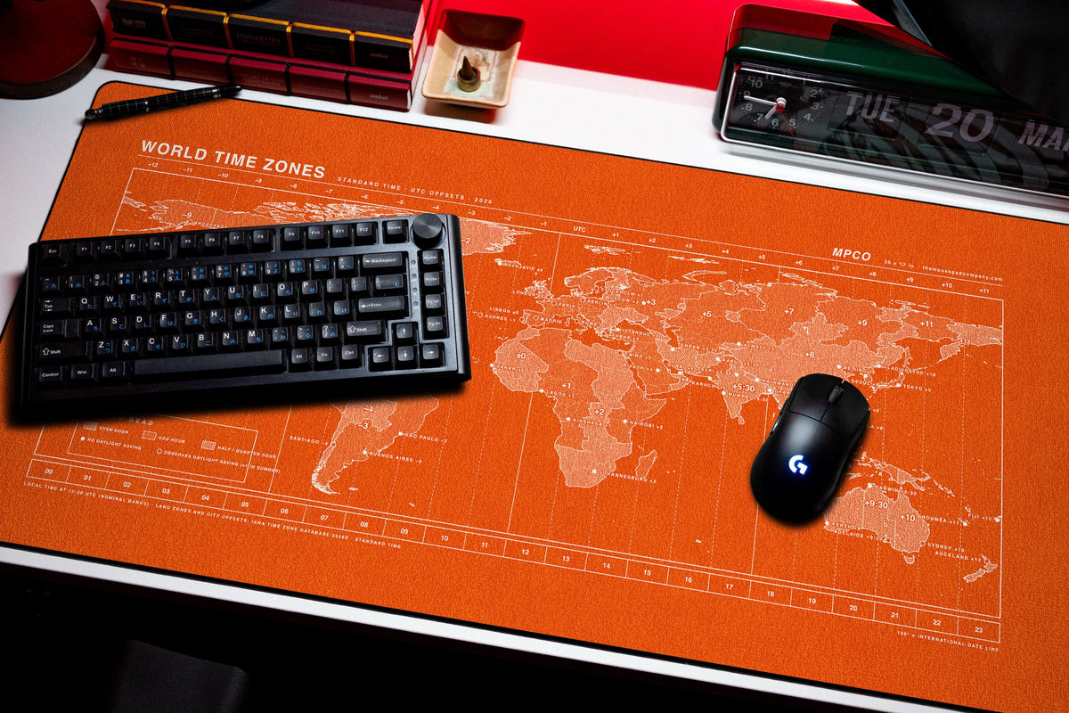 World Time Zones Map Pad desk mat in Orange / White, shown on a styled desk setup