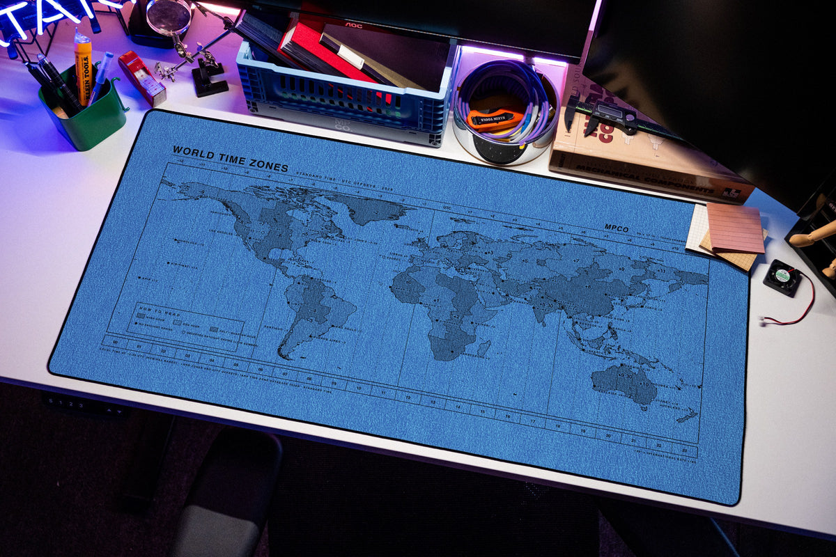 World Time Zones Map Pad desk mat in Swiss Blue, shown on a styled desk setup