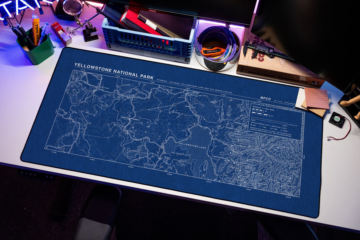 Yellowstone National Park Topo Pad desk mat in Blue / White, shown on a styled desk setup