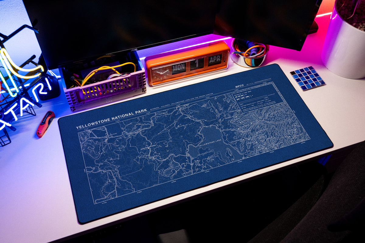 Yellowstone National Park Topo Pad desk mat in Blue / White, shown on a styled desk setup