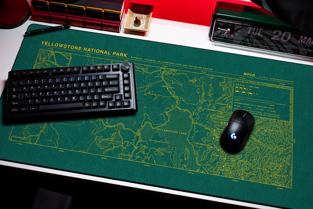 Yellowstone National Park Topo Pad desk mat in Green / Yellow, shown on a styled desk setup