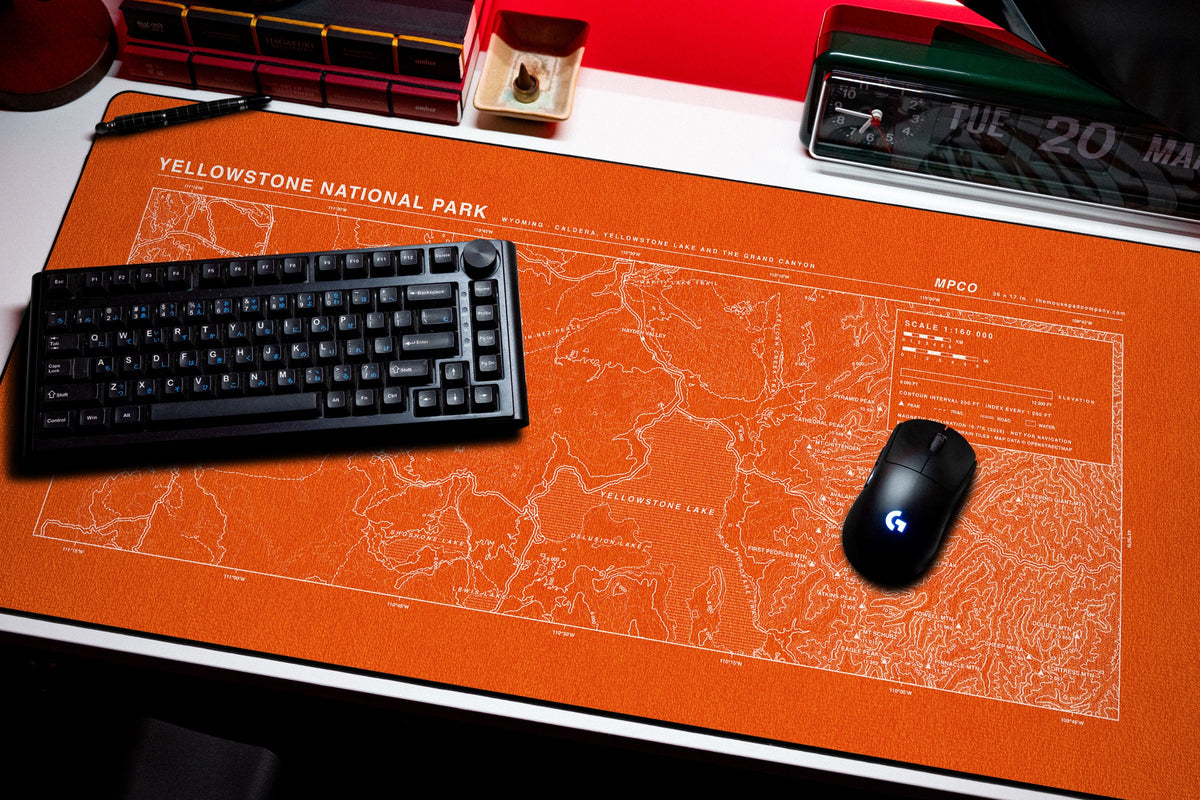 Yellowstone National Park Topo Pad desk mat in Orange / White, shown on a styled desk setup