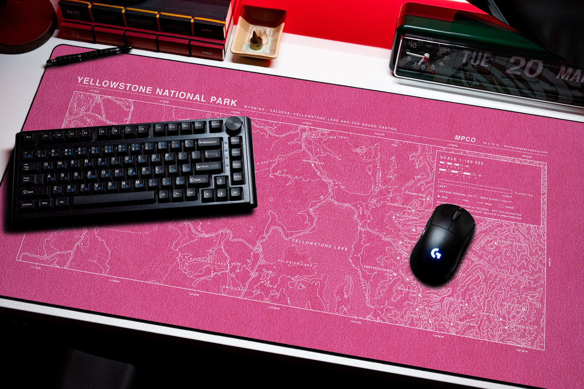 Yellowstone National Park Topo Pad desk mat in Pink / White, shown on a styled desk setup