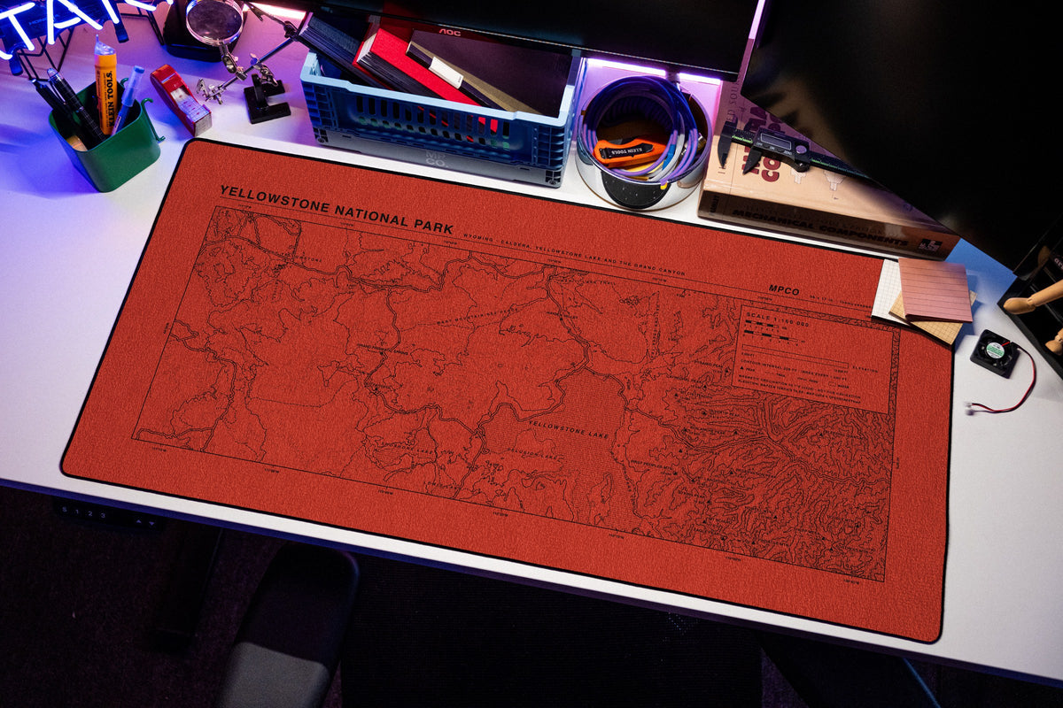 Yellowstone National Park Topo Pad desk mat in Red / Black, shown on a styled desk setup