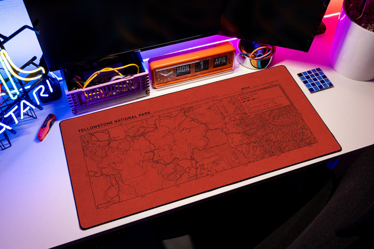 Yellowstone National Park Topo Pad desk mat in Red / Black, shown on a styled desk setup