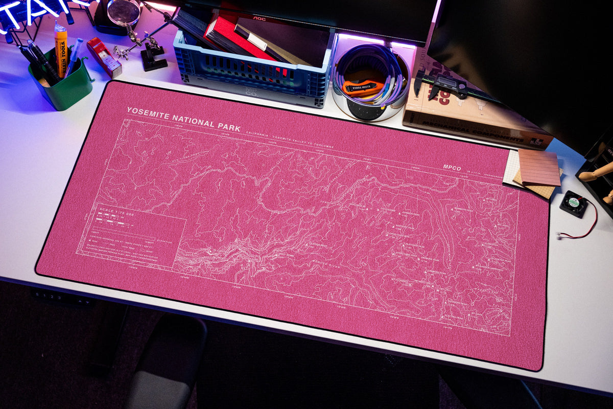 Yosemite National Park Topo Pad desk mat in Pink / White, shown on a styled desk setup