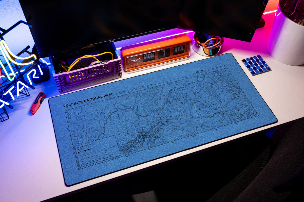 Yosemite National Park Topo Pad desk mat in Swiss Blue, shown on a styled desk setup