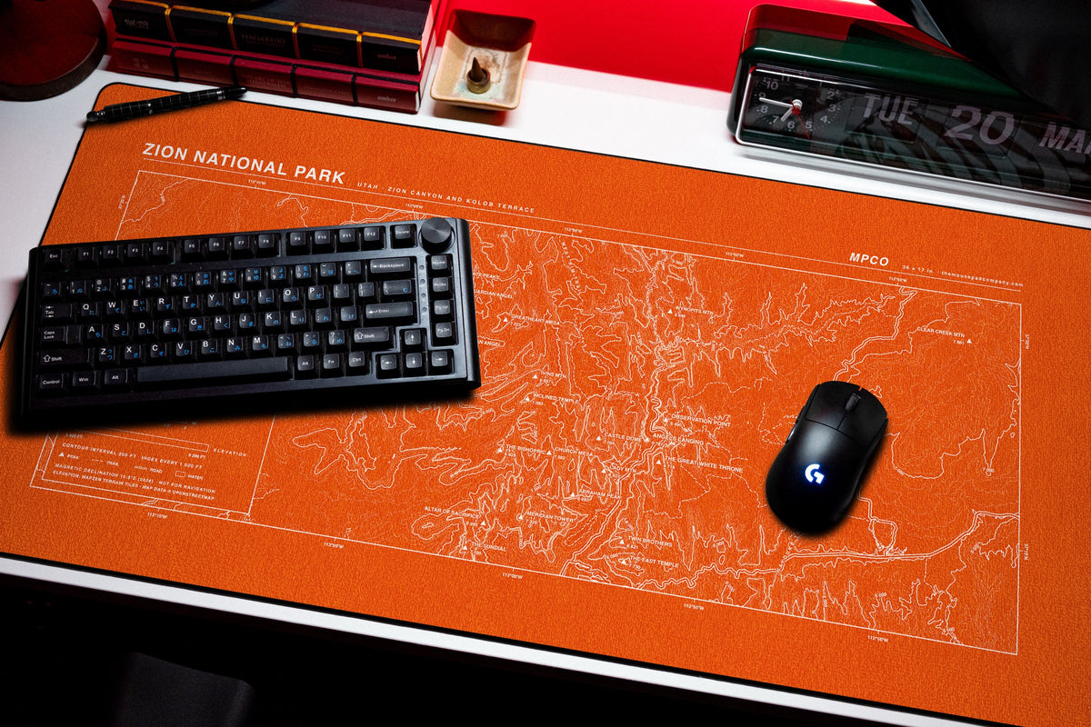 Zion National Park Topo Pad desk mat in Orange / White, shown on a styled desk setup