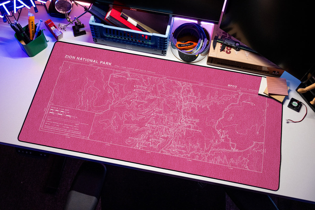 Zion National Park Topo Pad desk mat in Pink / White, shown on a styled desk setup